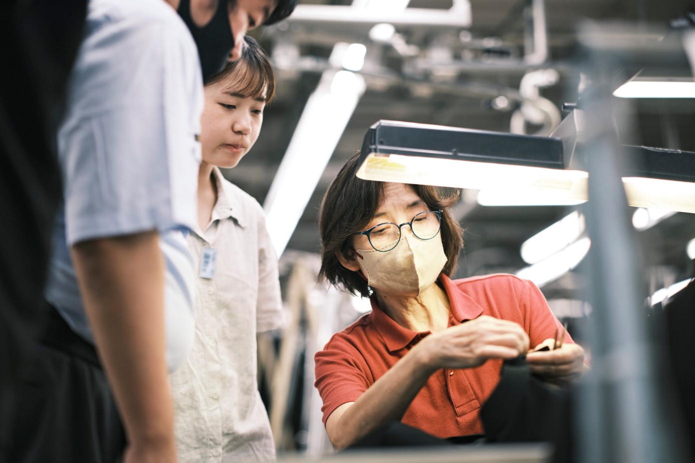 熟練の職人が若手に手元を教えている様子